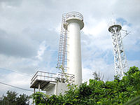 水納島の水納島灯台 - 携帯電話の鉄塔と並んでいます